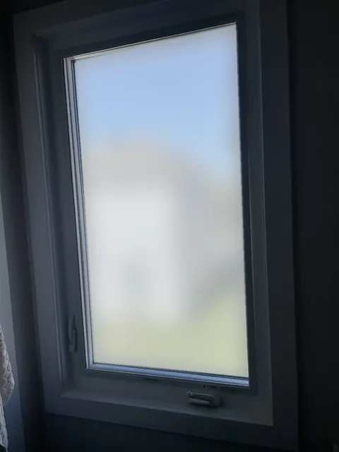 The same bathroom window shown with frosted privacy glass, daylight still coming in